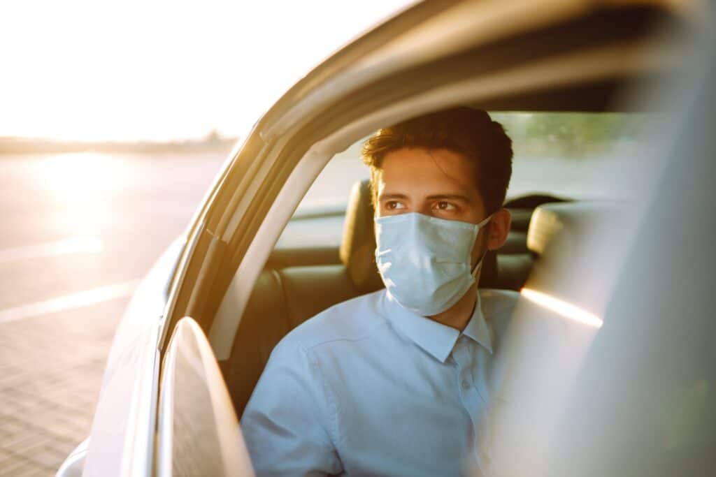 Man passenger in protective sterile medical mask in the taxi during an epidemic in quarantine city.