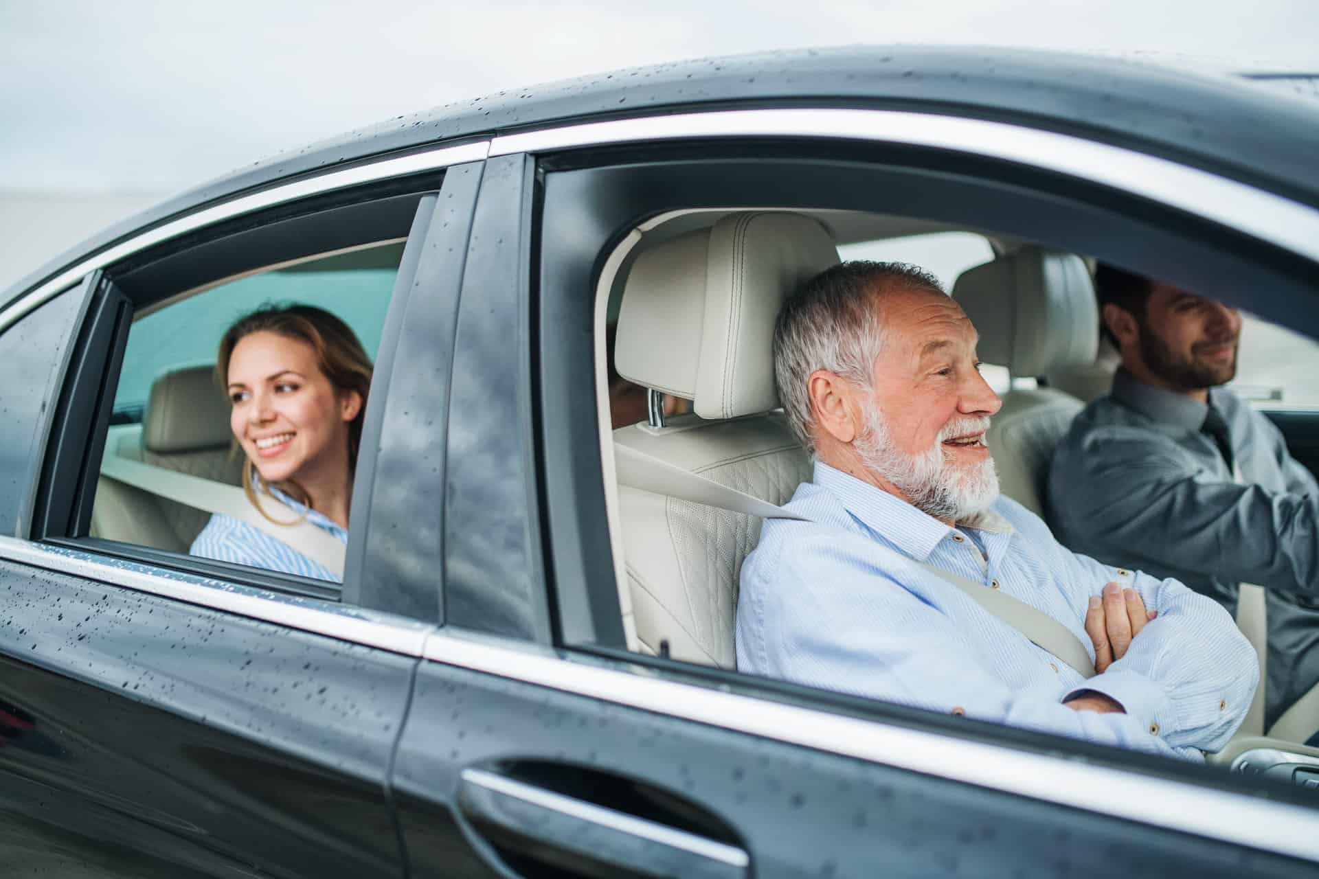 multigeneration family sitting in car driving